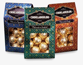 Foto av tre lyxiga chokladförpackningar i olika färger