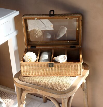 Foto av rottinglåda med textilier och blomdetalj