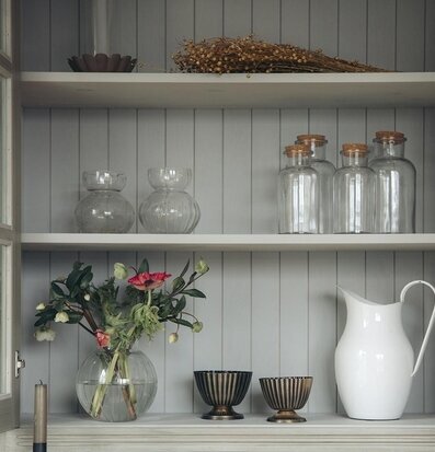 Foto av stilfull hylla med glas och porslinsföremål