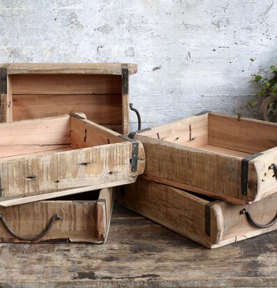 Foto av rustika trälådor med metallbeslag och växt