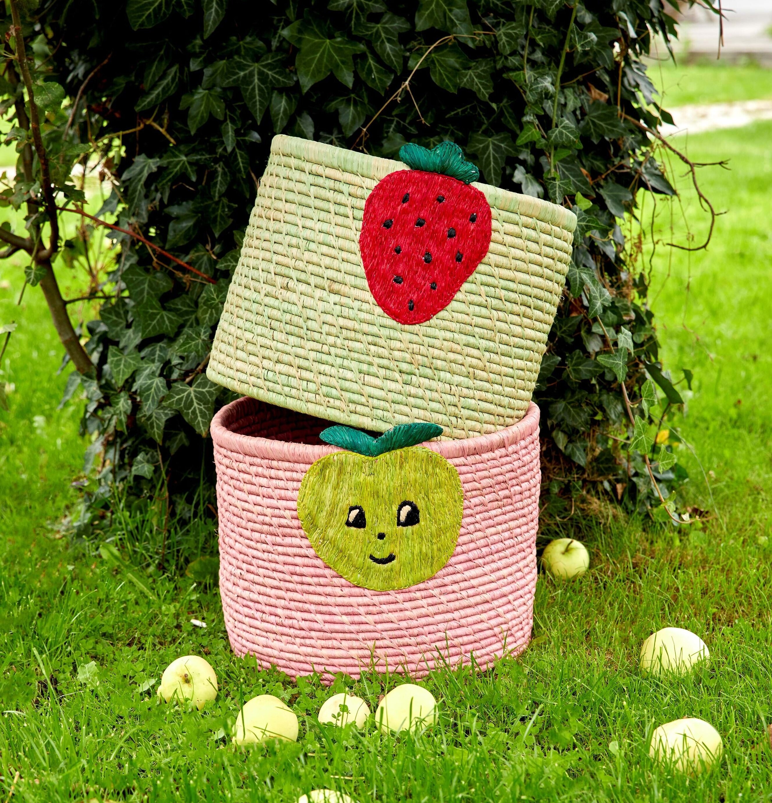 Rund Korg Soft Pink från Rice på gräsmatta med äpplen