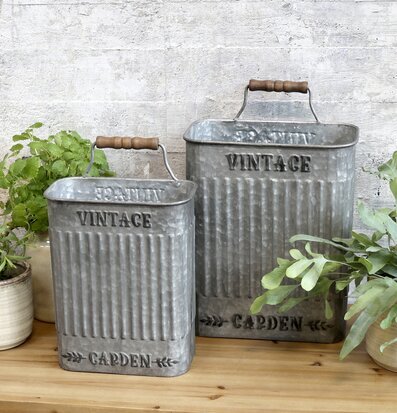 Bild av stilrena zinkbehållare med växter och ljus