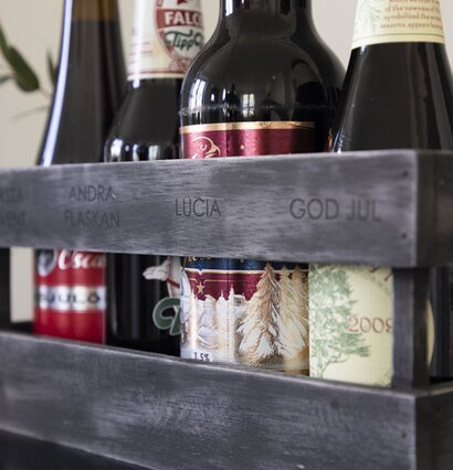 Foto av stilren trälåda med flaskor och inskriptioner