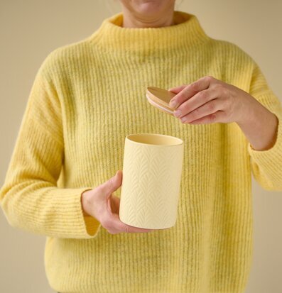 Bild av stilren gul keramisk förvaringsburk med trälock