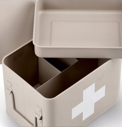 Bild av beige plåtburk med medicin-tema och vittt kors