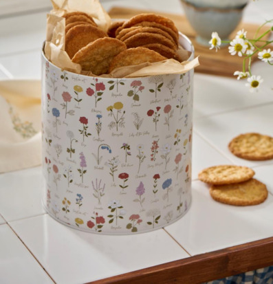 Bild av rund plåtburk med kakor och blommigt mönster