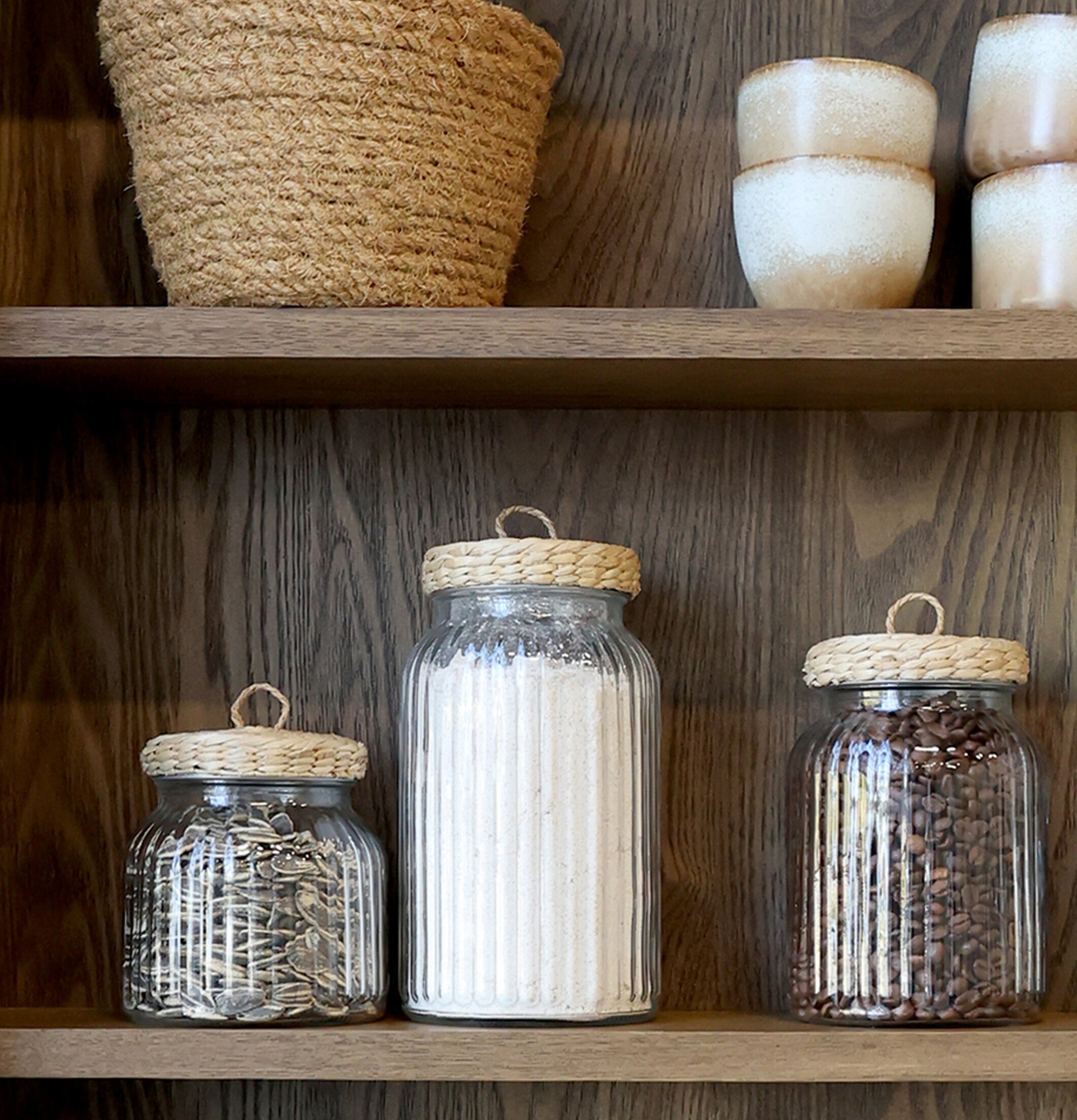 Bild av glasburkar med flätade lock och keramikdetaljer