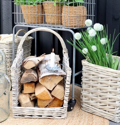 Bild av harmonisk scen med vedkorg och gröna växter