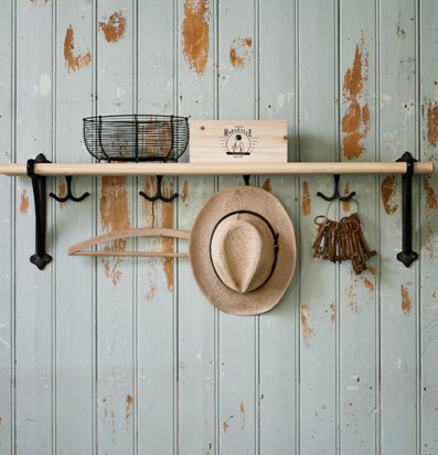 Bild av rustik hylla med trådkorg och krokar i metall