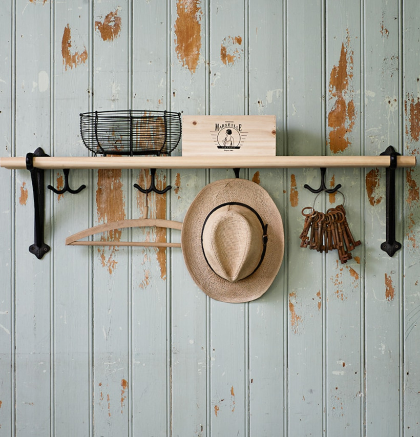 Bild av rustik hylla med trådkorg och krokar i metall