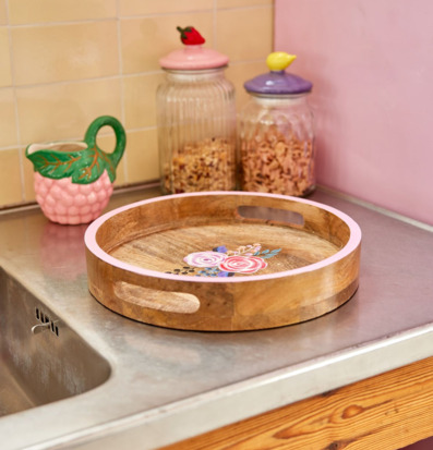 Bild av rund träbricka med blommor och färgglada köksdetaljer