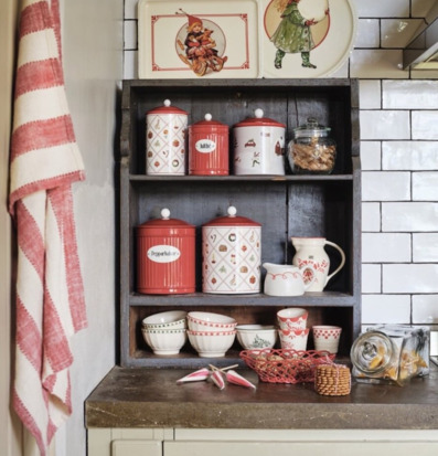 Bild av julig kökshylla med retro plåtburkar och vintermotiv