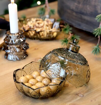 Bild av dukat bord med julkula i glas och säsongsdekorationer