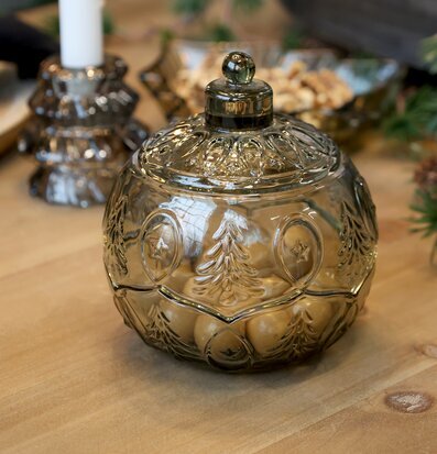 Bild av stämningsfull julmiljö med glasburk, ljus och nötter