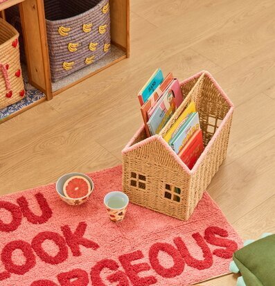 Foto: Husformad bokförvaring och rosa matta i rum