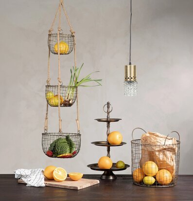 Bild av hängande trådkorgar i mässingston i kök