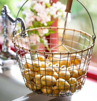 Foto: Rund trådkorg med potatis på ljus köksbänk
