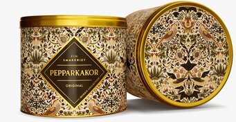 Foto av två plåtburkar med beige mönster och guldlock