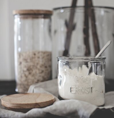 Bild av stilrena glasburkar med trälock i köksmiljö