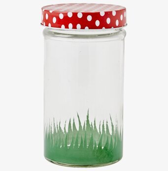Foto av glasburk med grön botten och rött lock
