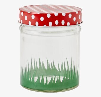Bild av glasburk med rött prickigt lock och grön bas