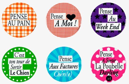 Foto av färgglada kylskåpsmagneter med franska budskap