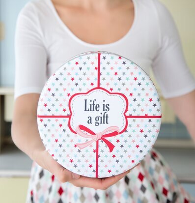 Bild av rund plåtburk med livfull och lekfull design