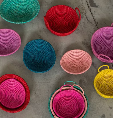 Bild av färgglada handflätade korgar på betongyta
