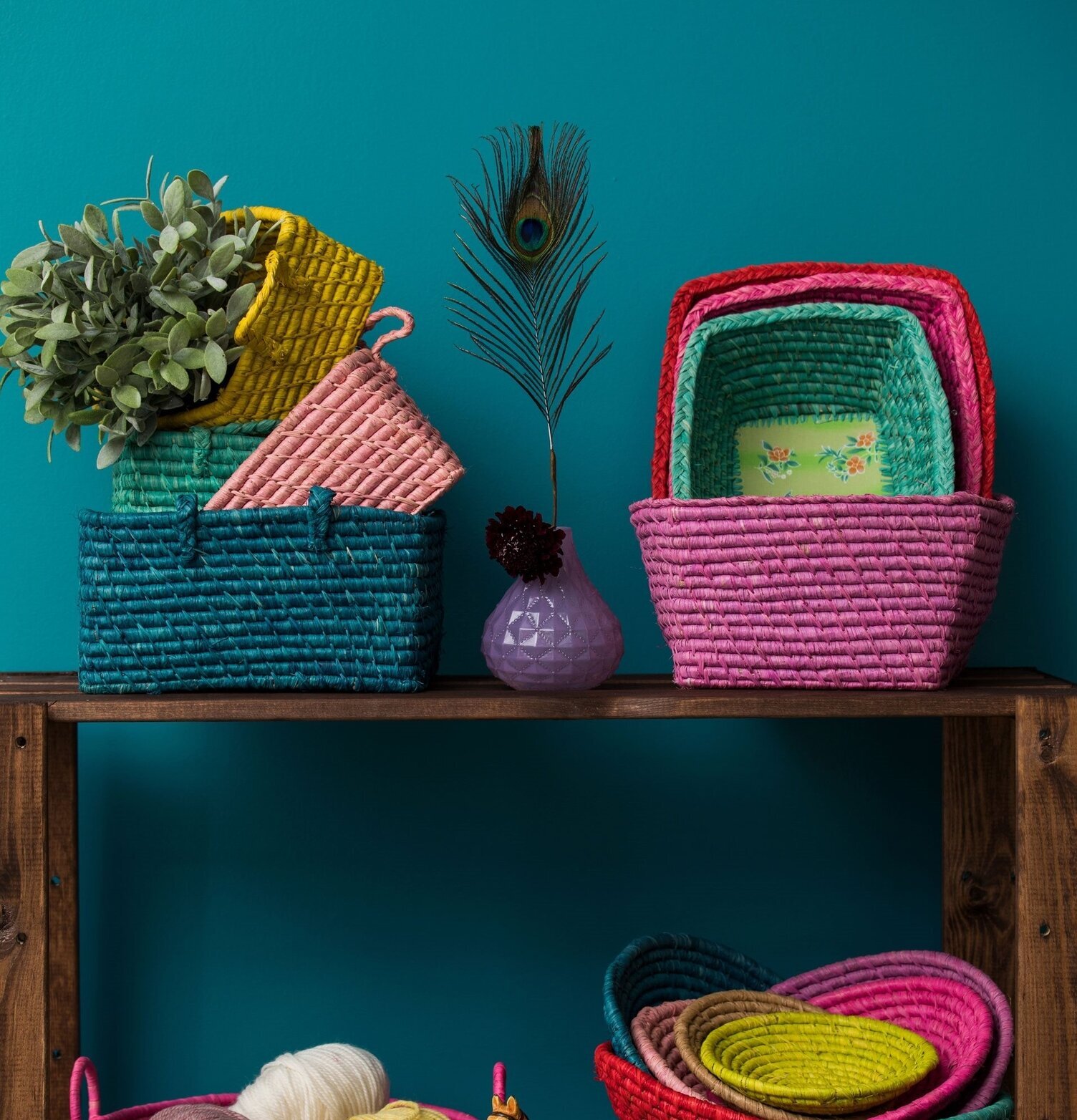 Förvaringskorgar Rice på hylla mot turkos vägg, färgglada