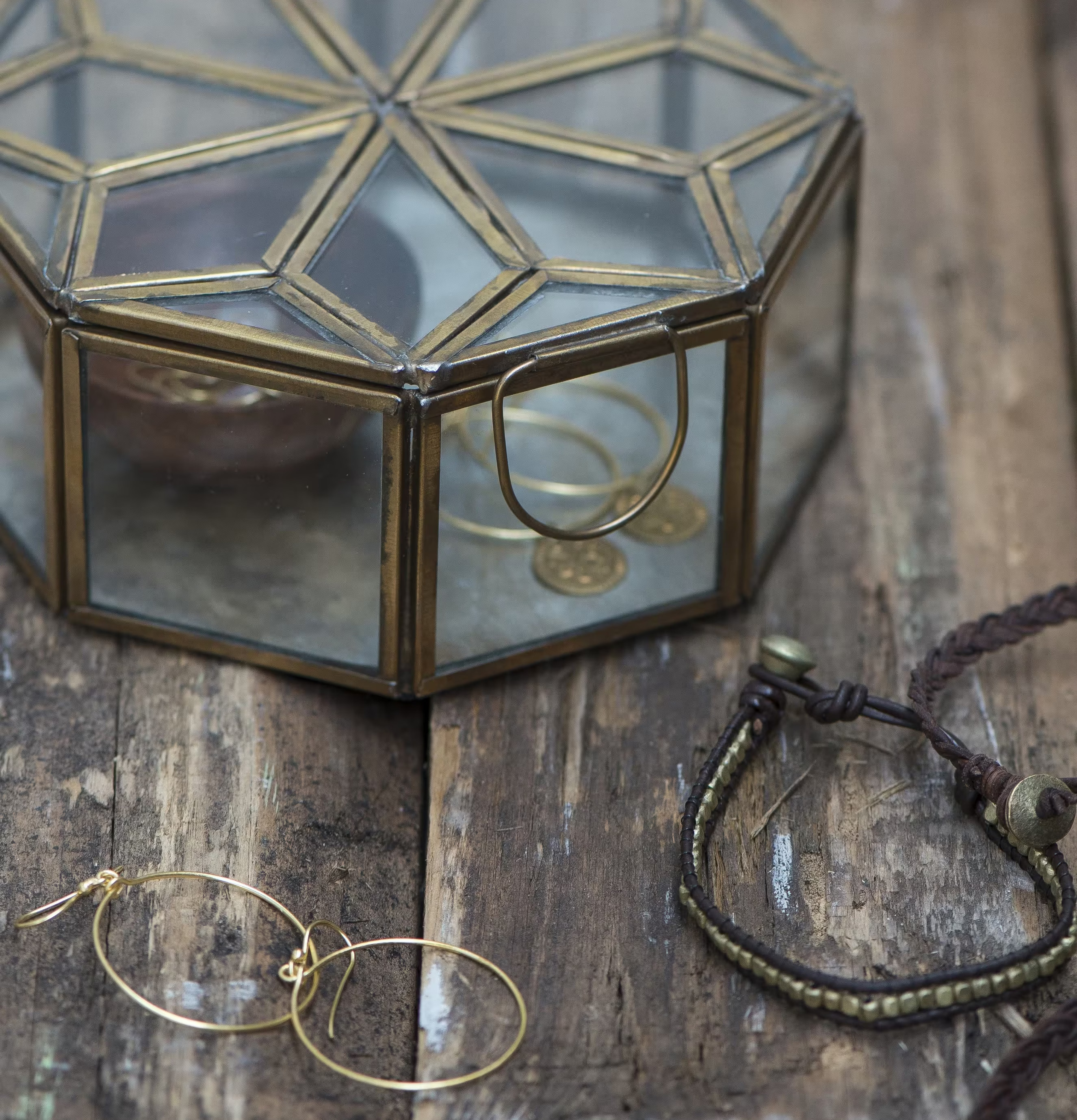 Bild av elegant glasbox med smycken och rustik bakgrund